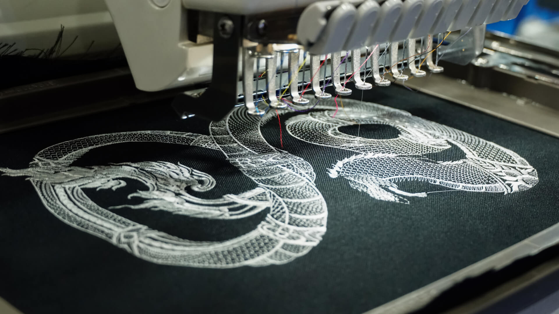 Precyzyjny haft smoka na czarnej tkaninie — seria